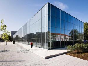 a glass building with two people standing in front of it at Ferienappartement im Herzen der Stadt in Dessau