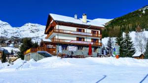 サン・ソルラン・ダルヴにあるChalet Beausoleil 4 étoiles - jacuzzi - au pied des pistes - domaine les sybellesの山前雪中大きな建物