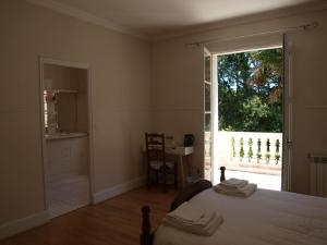 um quarto com uma cama e uma grande janela em LE CHEMINARD em Feugarolles