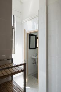 ein Bad mit einem Waschbecken und einem Spiegel in der Unterkunft Baixa24 •P2L• Apartamento T1 no centro histórico in Porto