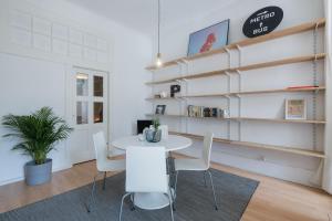 ein Esszimmer mit einem Tisch und weißen Stühlen in der Unterkunft Baixa24 •P2L• Apartamento T1 no centro histórico in Porto