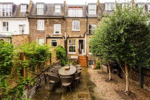 un patio avec des tables et des chaises en face d'un bâtiment dans l'établissement A Home on Northcote, à Londres