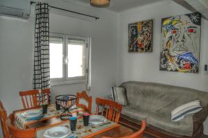 a living room with a couch and a table and chairs at Casa das 4 estações in Castelo Branco
