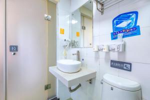 ein Badezimmer mit einem Waschbecken, einem WC und einem Spiegel in der Unterkunft 7Days Premium Beijing Wangjing in Peking