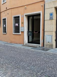 an open door of a building on a cobblestone street at San Pietro Apartment in Padova