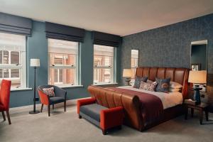Hotel du Vin Birmingham في برمنغهام: غرفة نوم بسرير وكرسي ونوافذ