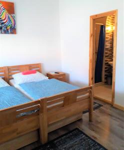 a bedroom with a large wooden bed with blue sheets at Kristály Vendégház in Bogács