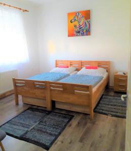 een slaapkamer met een groot houten bed met blauwe lakens bij Kristály Vendégház in Bogács