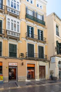 un edificio con ventanas y balcones en una calle en Homemalaga Constitución, en Málaga