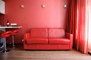 a red couch in a room with a red wall at Prinsenhuis in Amsterdam