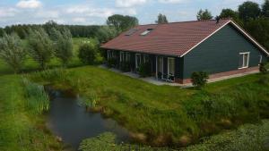 une maison avec une rivière devant elle dans l'établissement Boerderij "De Verwondering", à Goudriaan