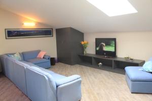 a living room with two blue couches and a tv at Giulimà B&B in Rocchetta SantʼAntonio