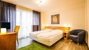 ein Hotelzimmer mit einem Bett und einem Stuhl in der Unterkunft Schroeders City-Style-Hotel in Trier