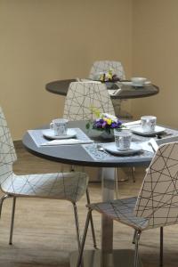 una mesa y sillas con tazas y flores. en Giulimà B&B en Rocchetta SantʼAntonio