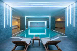 a pool with two chairs and a table in front of it at Cevahir Hotel Istanbul Asia in Istanbul