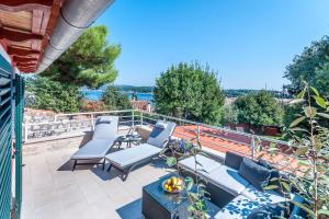 a patio with chairs and a table on a balcony at Villa Fema in Rovinj