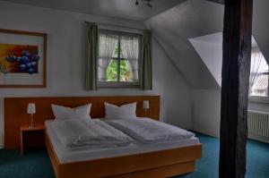 a bedroom with a large bed with a window at Hotel Alte Linden in Altena