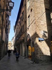 una mujer caminando por una calle al lado de un edificio en La Casa Di Betta, en Florencia