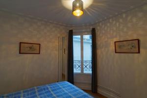 una camera con un letto blu e una finestra di Quiet apartment near Montmartre a Parigi