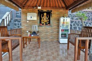 a room with a refrigerator and wooden tables and chairs at Surya Chandra Beach Bungalow in Nusa Penida
