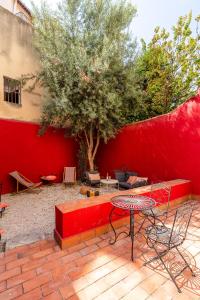 eine rote Bank und ein Tisch und ein Baum in der Unterkunft LE PANIER ENCHANTÉ - Suites & Loft - Terrasse et patio au dessus du Vieux Port in Marseille