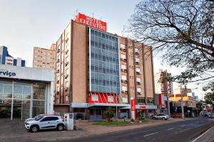 a building with a car parked in front of it at Hotel Suárez Executive Novo Hamburgo in Novo Hamburgo