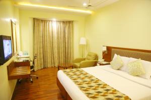 a hotel room with a bed and a chair at Royal Fort Hotel in Visakhapatnam