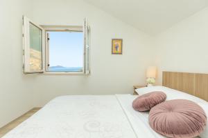 sypialnia z łóżkiem z różowymi poduszkami w obiekcie Hedera Estate, Hedera A53 w Dubrowniku