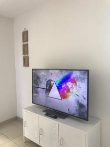 einen Flachbild-TV auf einem weißen Schrank in der Unterkunft Appartement au milieu des lacs, au bord du Guiers in Aoste