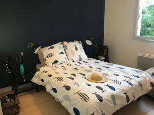 ein Bett mit einem Hut darauf in der Unterkunft Appartement au milieu des lacs, au bord du Guiers in Aoste + 9 Fotos