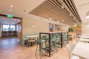 a restaurant with tables and chairs in a cafeteria at Maxhotel Amsterdam Airport Schiphol in Hoofddorp