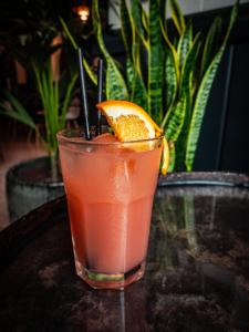 una bebida sentada en una mesa con una rodaja de naranja en Block, en Xlendi