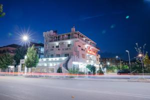 戈里察DEA Hotel 2002的一座白色的大建筑,晚上有灯