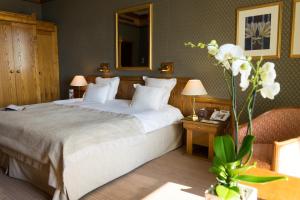 - une chambre d'hôtel avec un lit et un miroir dans l'établissement Le Grand Hôtel - Domaine De Divonne, à Divonne-les-Bains