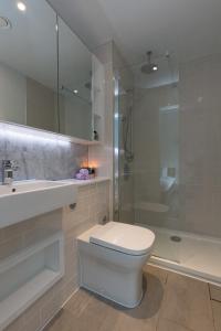 La salle de bains est pourvue de toilettes, d'un lavabo et d'une douche. dans l'établissement Deluxe Central London Apartment, à Londres