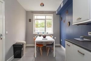 eine Küche mit einem Tisch und Stühlen sowie einem Fenster in der Unterkunft Ashland House in Milton Keynes
