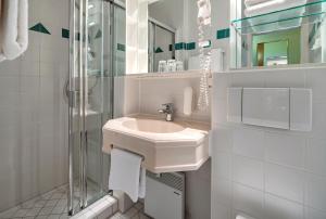 ein weißes Badezimmer mit Waschbecken und Dusche in der Unterkunft AHORN Panorama Hotel Oberhof in Oberhof