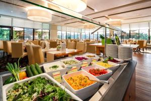 ein Buffet mit vielen Schüsseln Essen drauf in der Unterkunft AHORN Panorama Hotel Oberhof in Oberhof