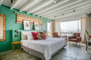 a bedroom with a large bed with a green wall at NAIA Miraflores Lima- Formerly Selina Miraflores Lima in Lima