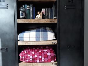 a black book shelf with pillows and books at 10 Via Giuseppe Sirtori in Milan