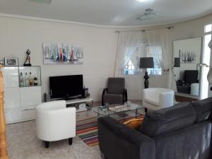 a living room with a couch and chairs and a tv at casa ronda in Rojales