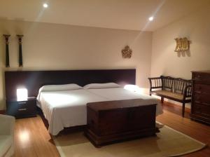 a bedroom with a large white bed and a chair at Galican Casa Rural in Moriscos