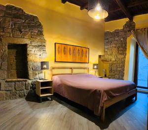 1 dormitorio con 1 cama grande y pared de piedra en Al Cardinale, en Viterbo