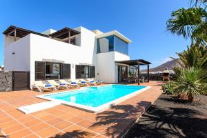 una villa con piscina di fronte a una casa di Hipoclub Villas,"Tabaro"villa a Playa Blanca