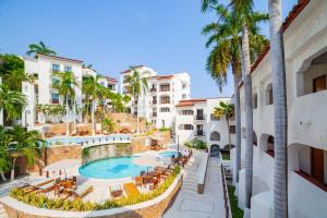 a view of a resort with a swimming pool and palm trees at Hotel Marina Resort & Beach Club in Santa Cruz Huatulco