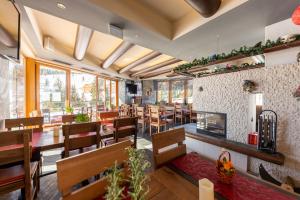 a restaurant with tables and chairs and a fireplace at Sissi Park in Lachtal