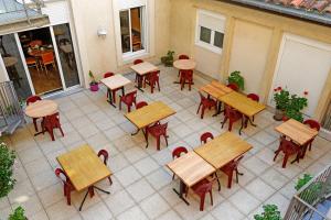 un patio con vistas panorámicas a las mesas y sillas en Hôtel du Vigan en Albi