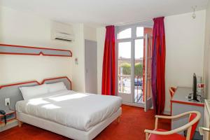 a bedroom with a white bed and a window at Hôtel du Vigan in Albi