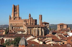 un gran edificio con dos torres en la cima de una ciudad en Hôtel du Vigan en Albi