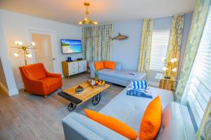 a living room with a blue couch and an orange chair at Seaside All Suites Hotel in Miami Beach
